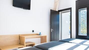 Une chambre à coucher moderne avec un lit, un bureau et un téléviseur.