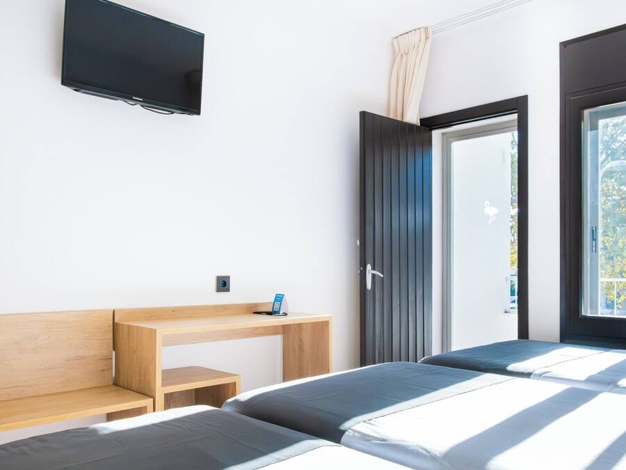 Une chambre à coucher moderne avec un lit, un bureau et un téléviseur.