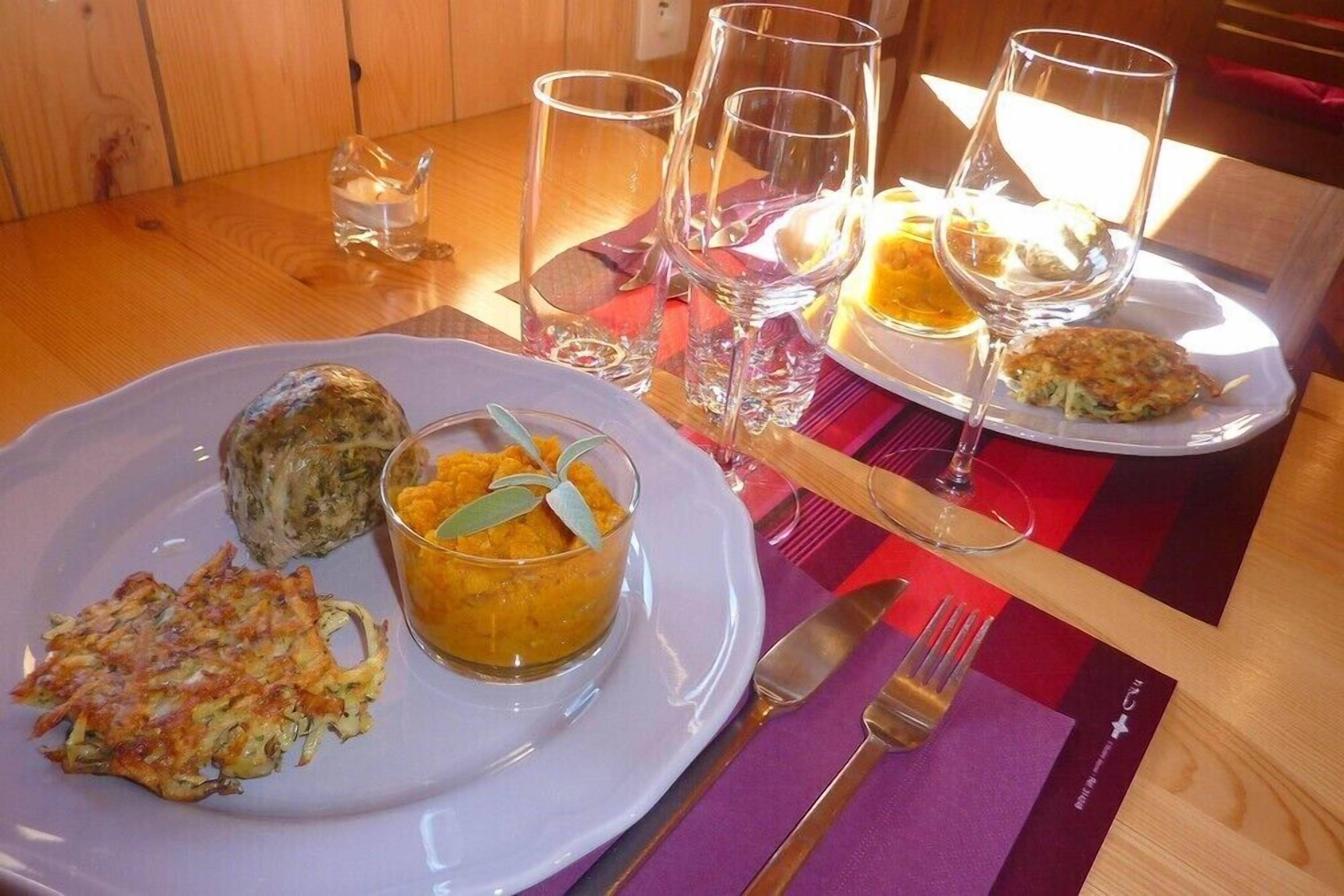 A table with plates of food, glasses, and cutlery.