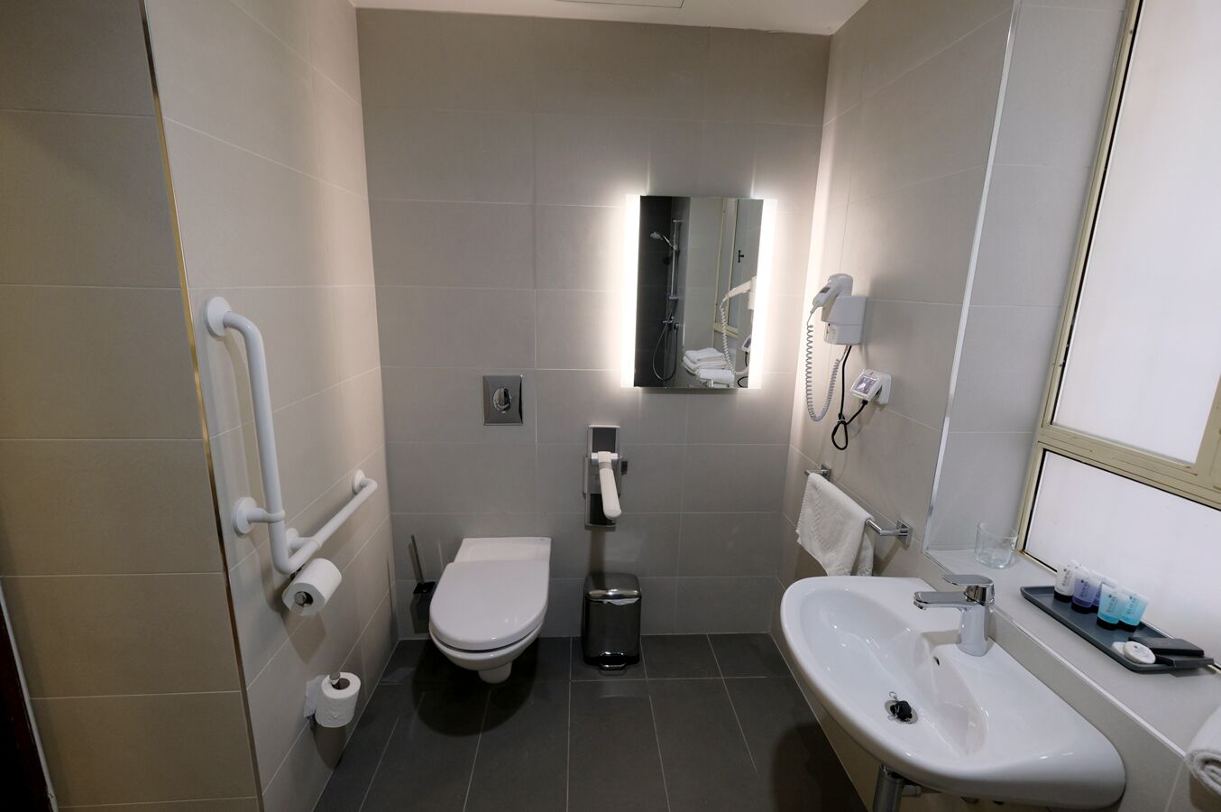A compact bathroom with a toilet, bidet, and sink.