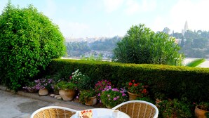 Un patio con sillas de mimbre, una mesa con comida y plantas en macetas.