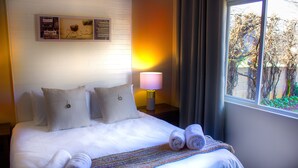 A neatly made bed with pillows, a rolled towel, and a blanket. - Hesperus Street (Alberton)