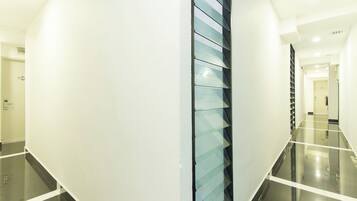 Un interno moderno con una parete divisoria in vetro, un pavimento pulito e una porta con un cartello.