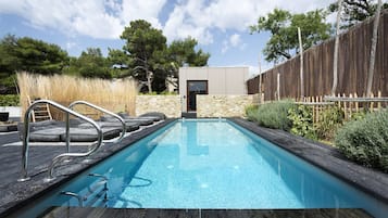 Una piscina al aire libre de temporada, sombrillas