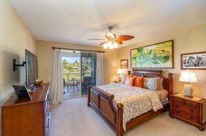 A bedroom with a bed, a desk, a chair, a ceiling fan, and a view of the outdoors. - Golf S G2 At Mauna Lani Resort 3 Bedroom Townhouse by RedAwning (Kamuela)