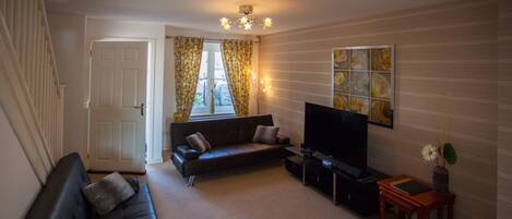 A living room with a sofa, a television, and a small table.