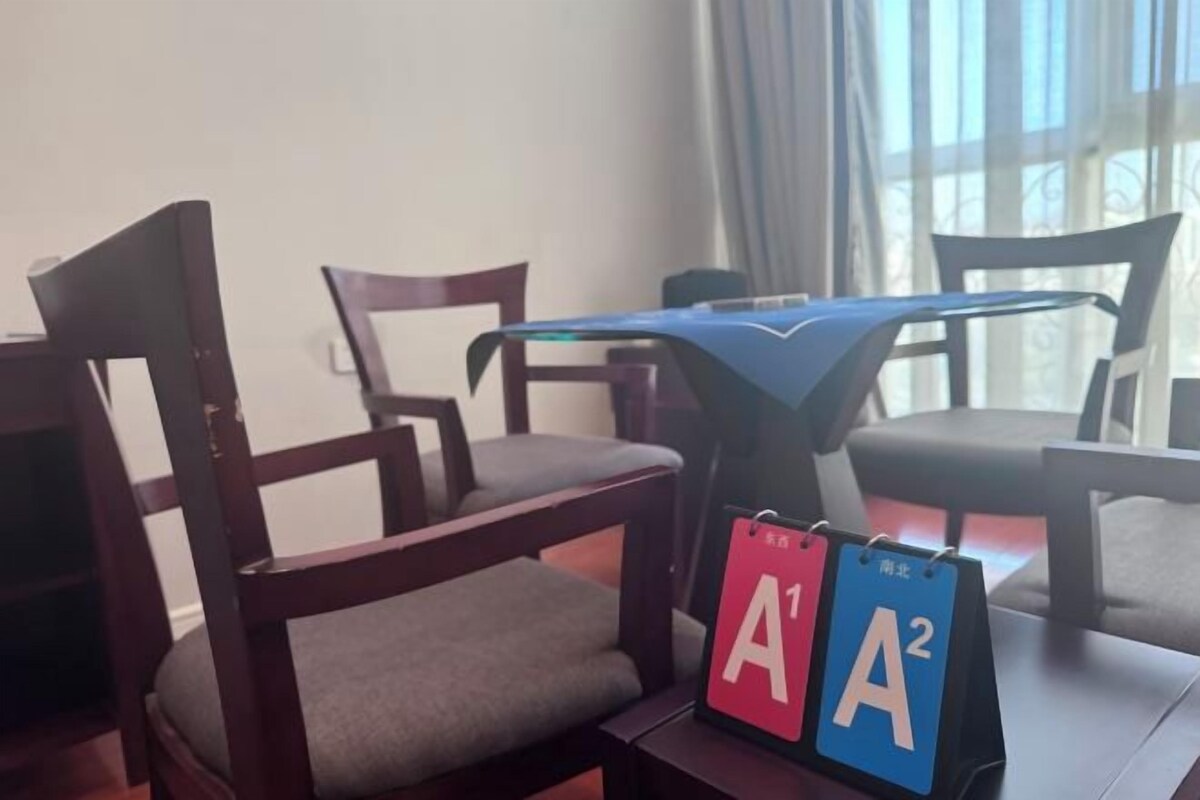 Une pièce comprenant une chaise en bois, une petite table et un calendrier indiquant les dates « A1 » et « A2 ».