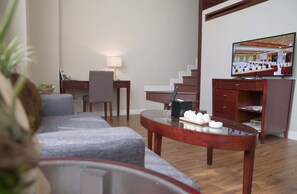 Ein modernes Wohnzimmer mit einer Couch, einem Couchtisch, einem Fernseher und einer Treppe.