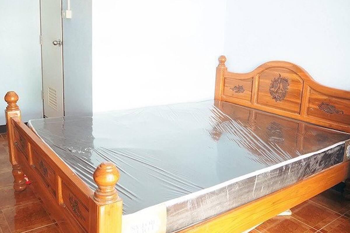 A wooden bed with a metal frame and a mattress.