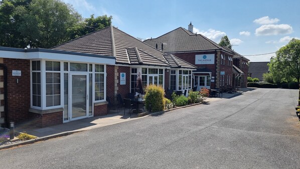 A two-story building with a sign reading "The Avenue."