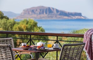 A dining table with breakfast items and a view of a mountainous landscape.