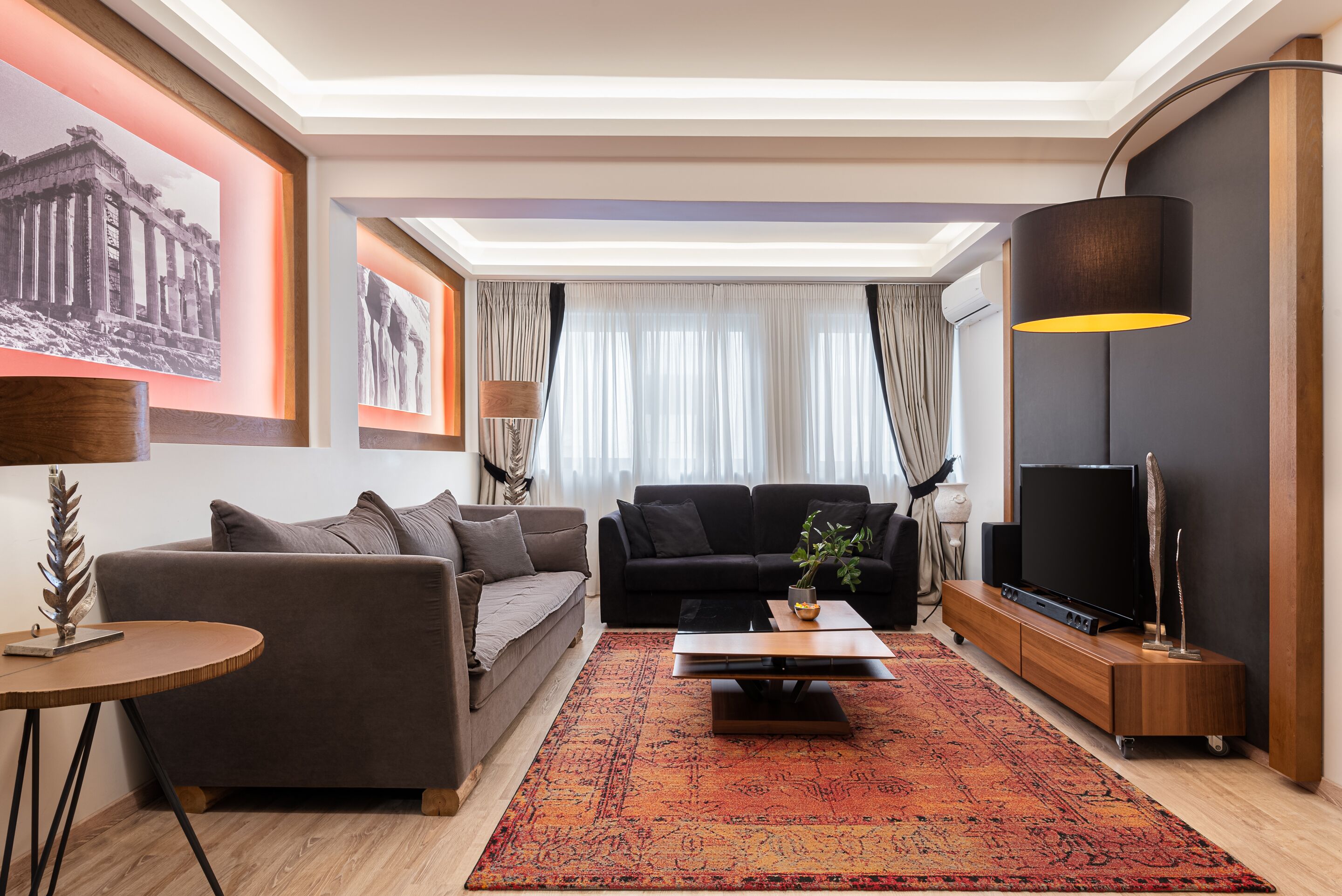 A modern living room with a sofa, coffee table, and TV stand.