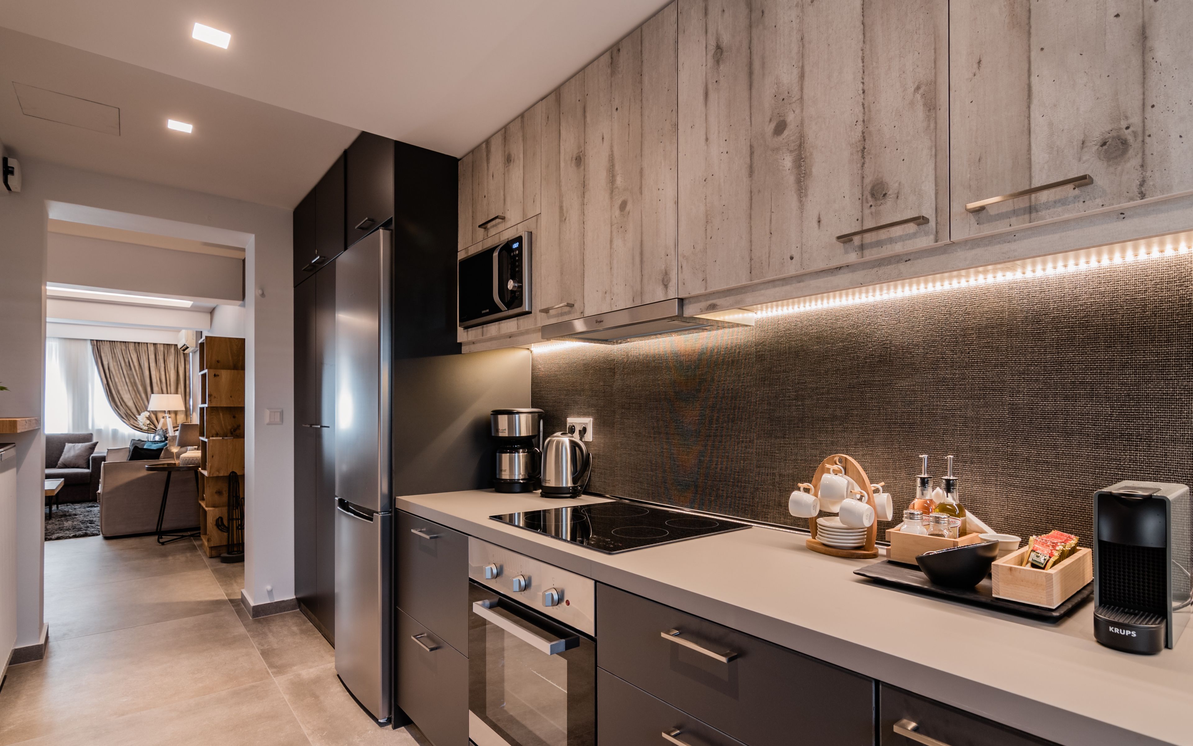 A modern kitchen with wooden cabinets, stainless steel appliances, and a built-in microwave.