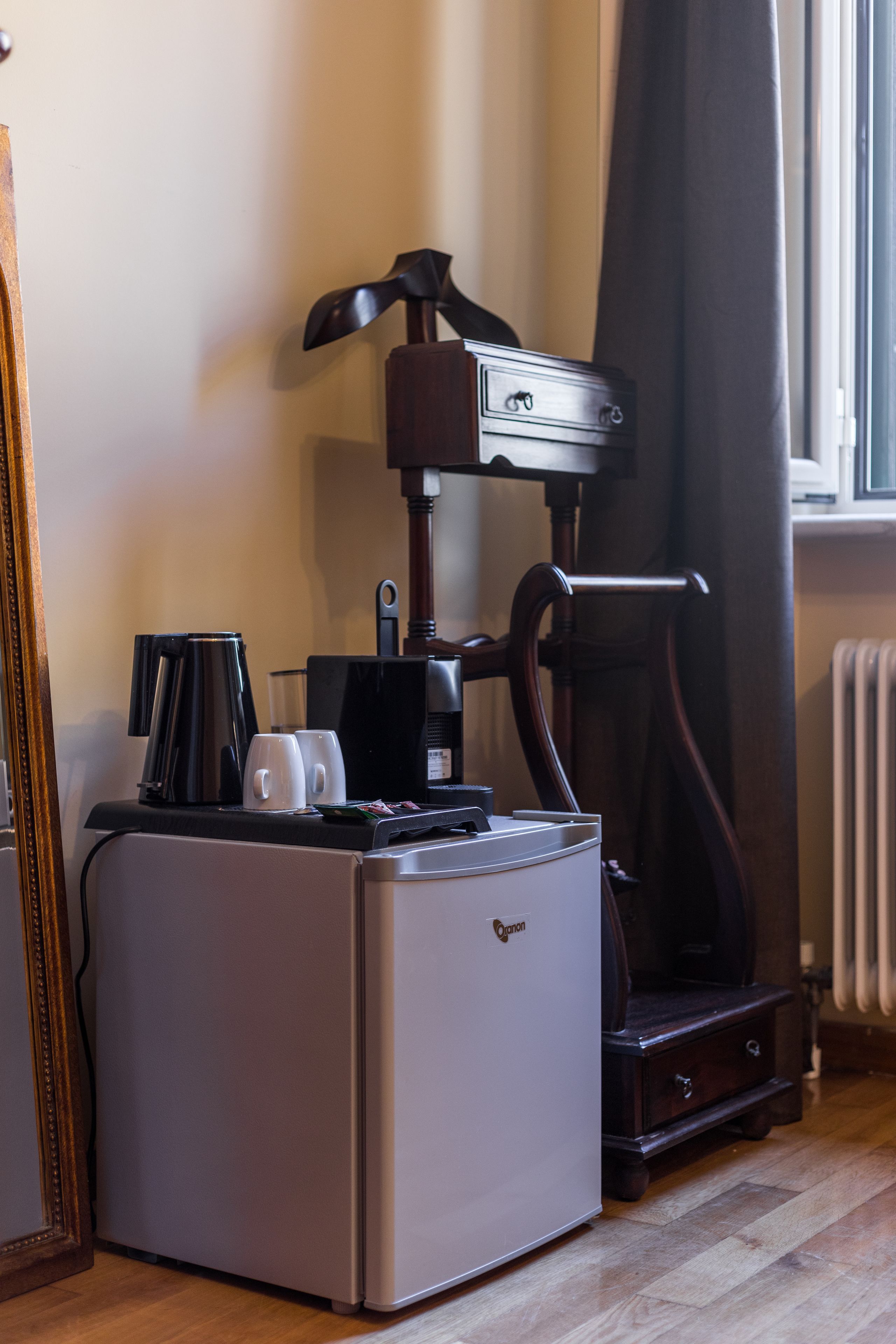 A compact kitchenette with a coffee maker, two mugs, and a toaster.