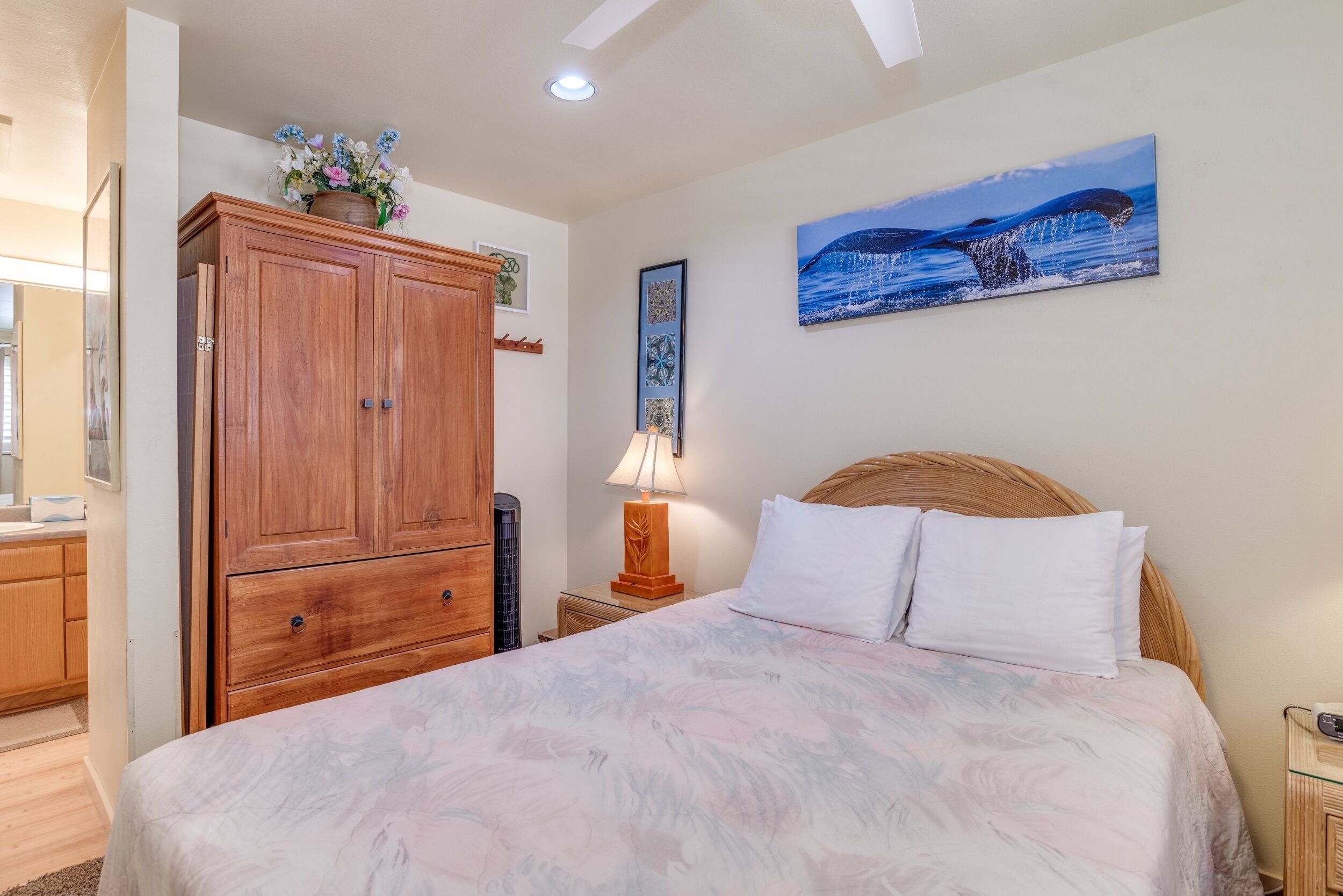 Une chambre à coucher avec un lit, une armoire en bois et un tableau accroché au mur.
