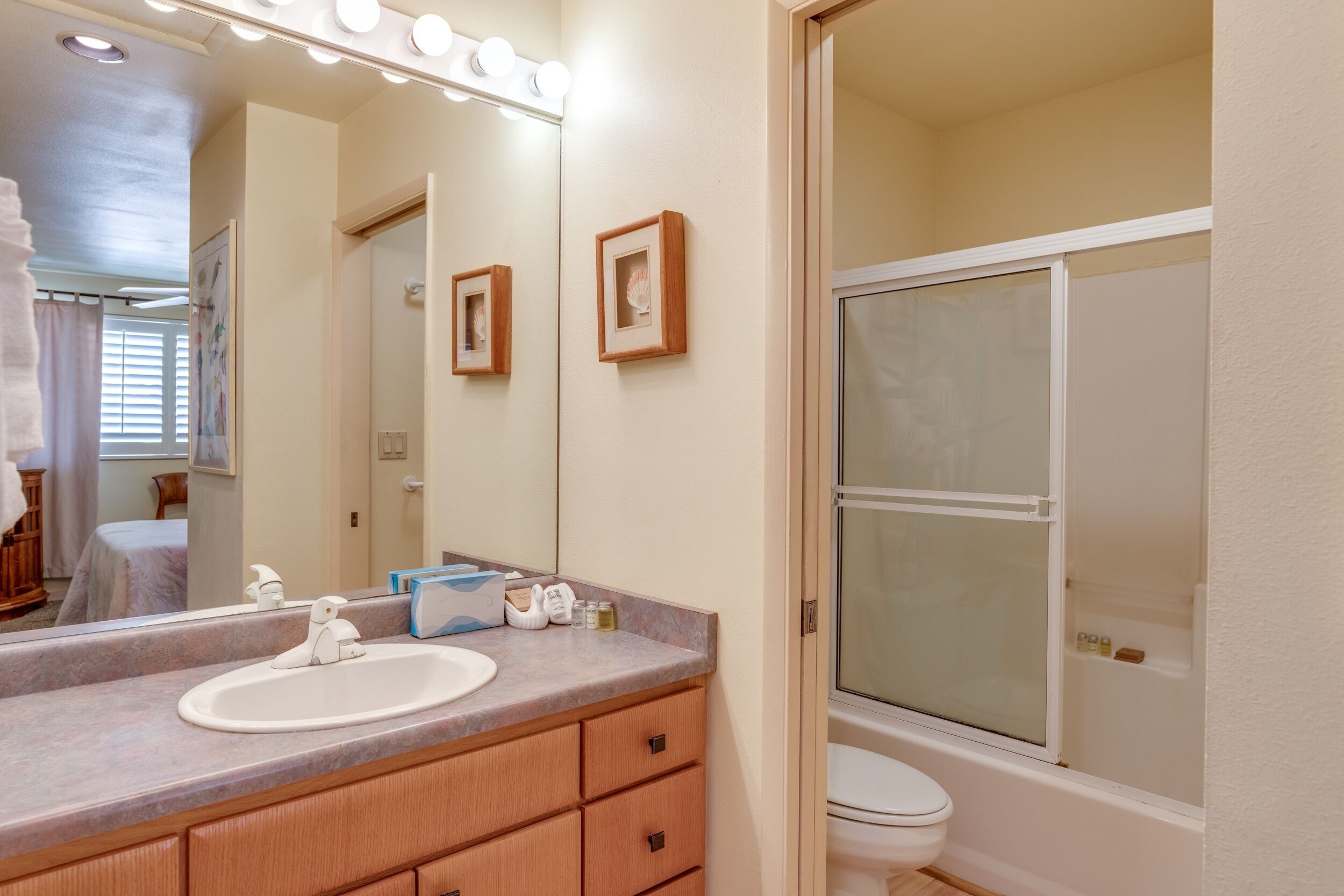 Une salle de bain équipée d’un lavabo, d’un miroir, d’un meuble-lavabo et d’un espace douche.