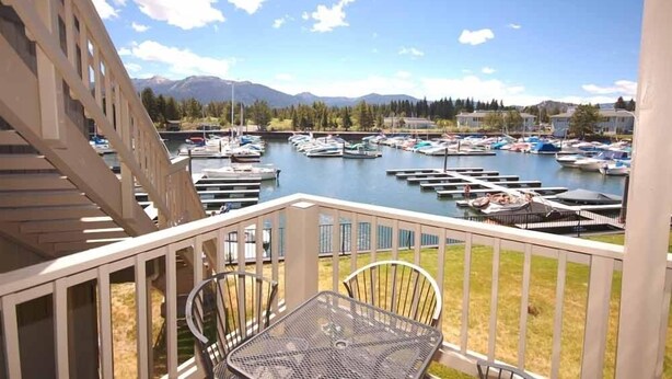 A balcony with a view of a marina and mountains in the background.