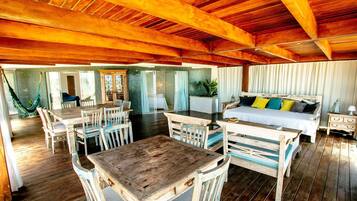 Une pièce au plancher de bois, avec un lit, une table à manger et des chaises.