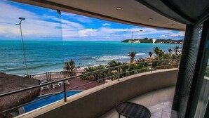 Ein Balkon mit Blick auf den Ozean und einen Pool.