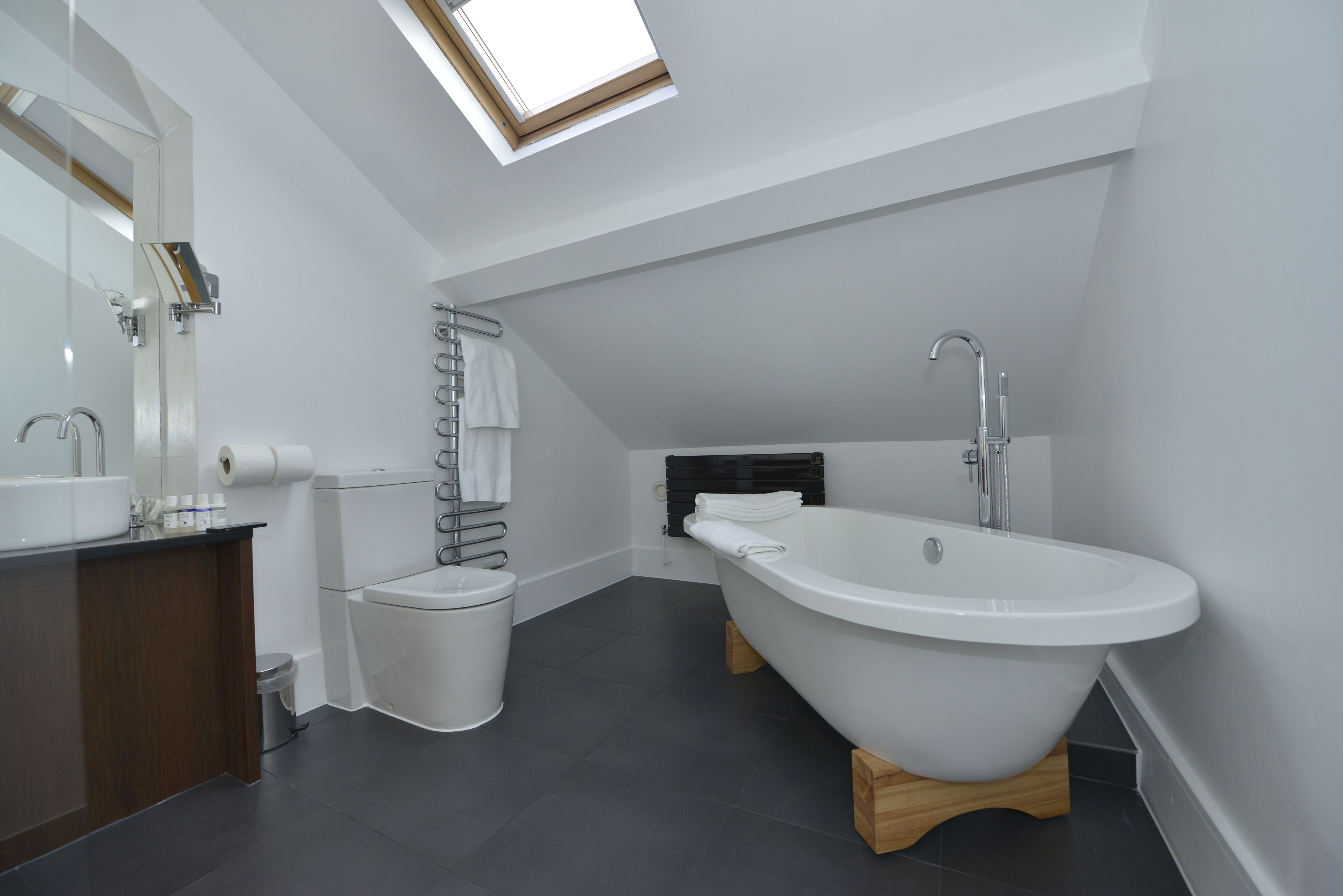 A modern bathroom with a freestanding bathtub, a toilet, and a sink.