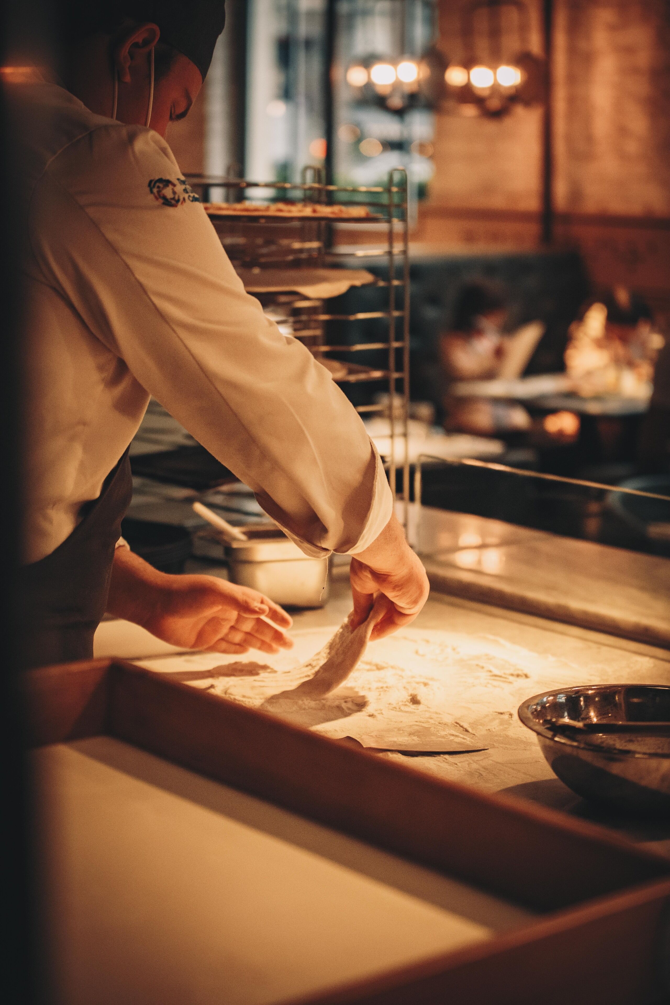 A chef preparing food in a kitchen with a focus on the cooking process.