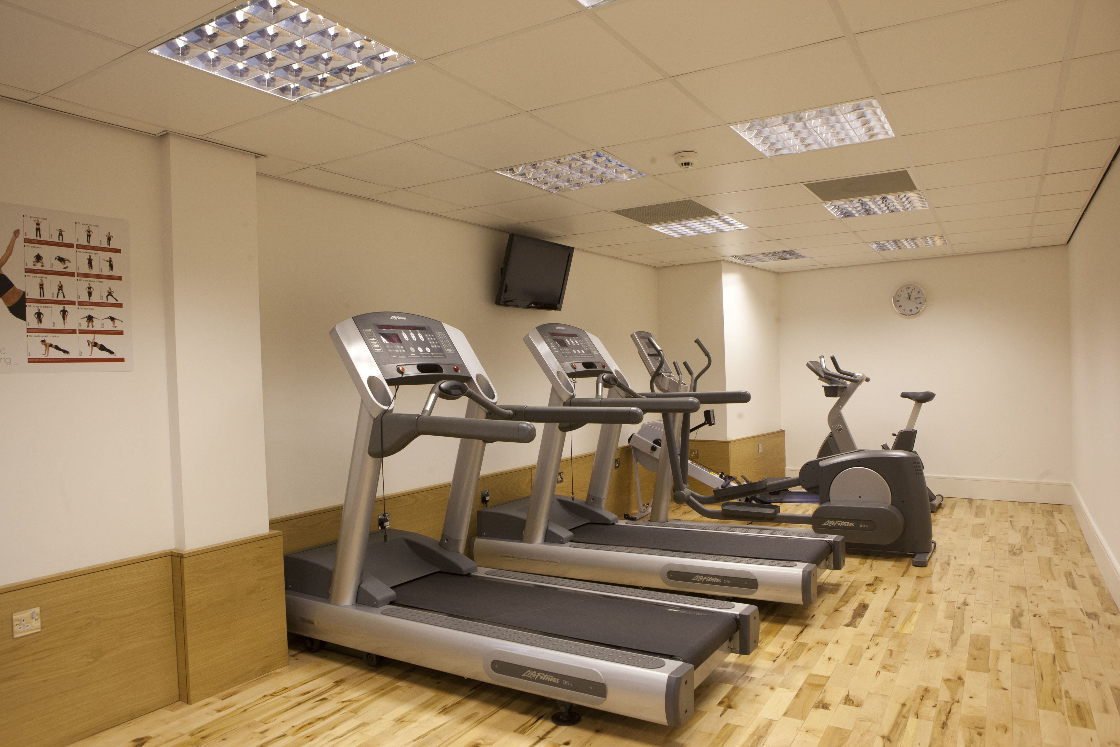 A gym with treadmills, elliptical machines, and a stationary bike.