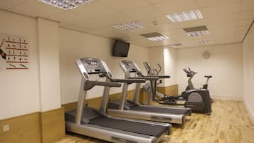A gym with treadmills, elliptical machines, and a stationary bike.