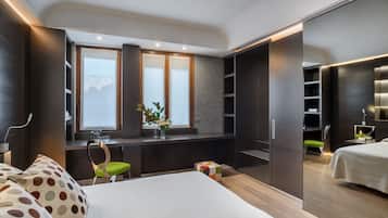 A modern bedroom with a bed, a desk with a chair, a wardrobe, and a window with a view.