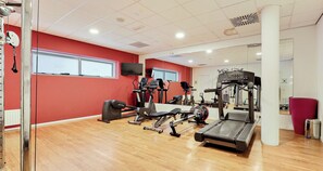A gym with cardio machines, weightlifting equipment, and a mirrored wall. - PLAZA Premium Grand Winston (Rijswijk)