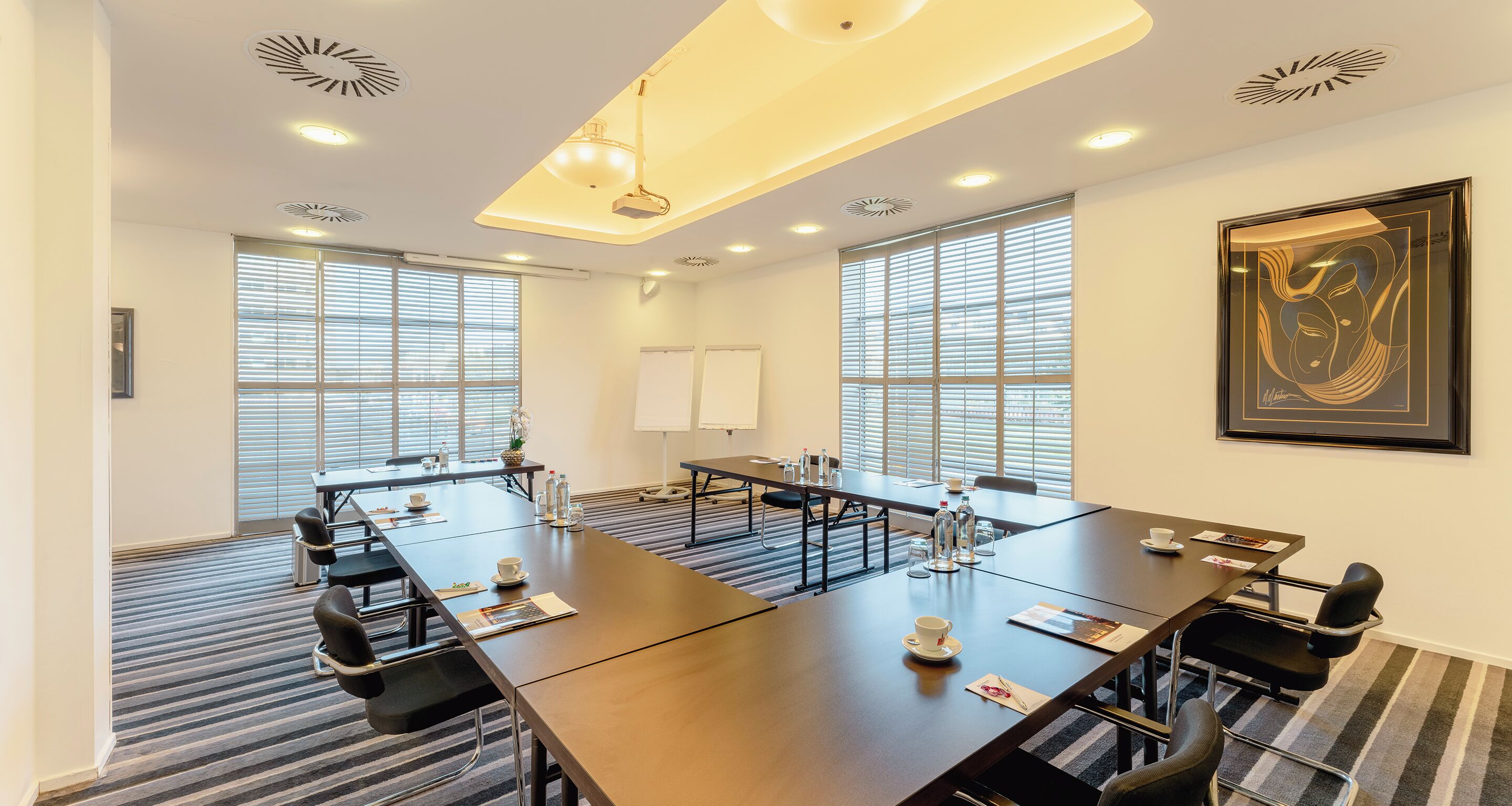 A conference room with a long table, chairs, and a whiteboard.