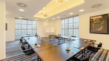 A conference room with a long table, chairs, and a whiteboard.