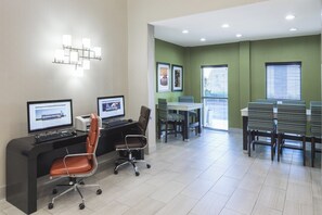 A modern office space with two desks, chairs, and a dining area.