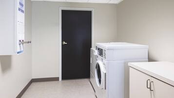 Un cuarto de lavado con una puerta, una lavadora y una secadora.