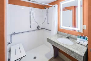 A modern bathroom with a shower, grab bar, sink, and a mirror. - Holiday Inn Express & Suites Atlanta NE - Duluth by IHG (Duluth)