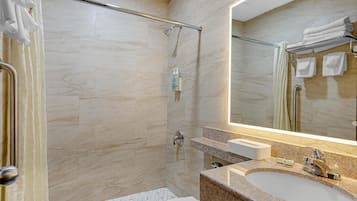 Ein modernes Badezimmer mit Dusche, Waschbecken und Spiegel.