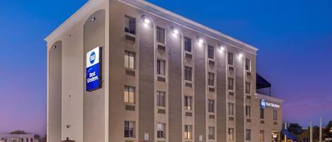A Best Western hotel with a modern facade, multiple floors, and a parking lot with several cars.