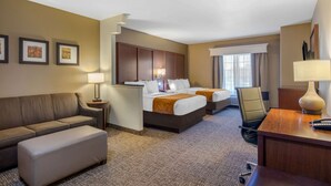 A hotel room with two beds, a sofa, a desk, and a chair. - Comfort Suites Marshall (Marshall)