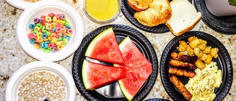 Una mesa de desayuno con diversos alimentos servidos en platos.