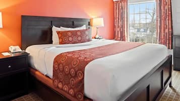 Relax in comfort with a large bed, two nightstands, and a large window with curtains.