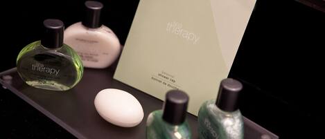 A tray with various toiletries including a green bottle labeled 'spa therapy', a white bottle, and a small white oval object.