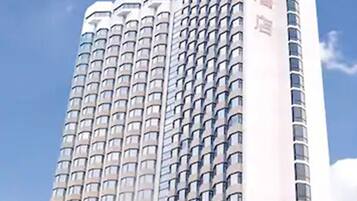 Un hotel de gran altura con varios balcones y un cielo despejado.