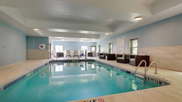 An indoor swimming pool with clear water, a tiled floor, and a sign indicating a depth of 5 feet 1.5 meters. - Holiday Inn Express Hinesville by IHG (Hinesville)