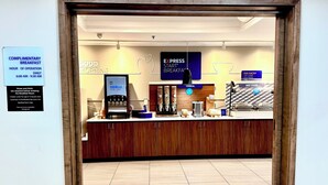 A breakfast area with a coffee machine, cereal, and hot food options. - Holiday Inn Express Hinesville by IHG (Hinesville)
