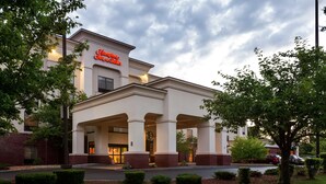 A hotel with a prominent sign, a covered entrance, and a well-maintained lawn. - Hampton Inn & Suites Manchester-Bedford (Bedford)