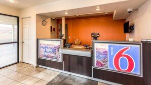 A hotel reception area with a digital display board, a clock, and a security camera. - Motel 6 El Paso, TX - East (El Paso)