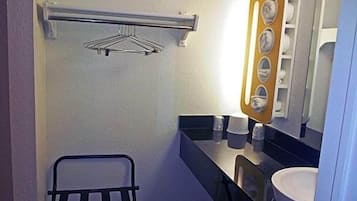 Un baño pequeño con un perchero, un espejo con marco de madera y un lavabo.