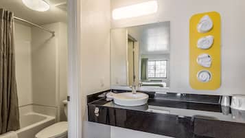 Un baño con bañera, inodoro, lavabo y espejo.
