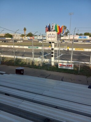 Un estadio con varias banderas, un cubo de basura y un letrero que dice 'WHELEN'.