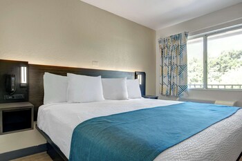 A hotel with a swimming pool, multiple balconies, and outdoor seating areas. at Motel 6 Venice, FL