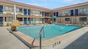 A pool area with a 3ft 9in depth, lounge chairs, and a covered seating area. - Motel 6 Venice, FL (Venice)